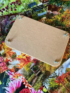 The Bishy Barnabees Cottage Garden Wooden Flower Press - Standard, with four corner screws, rests atop a spread of colorful garden and flower photos.